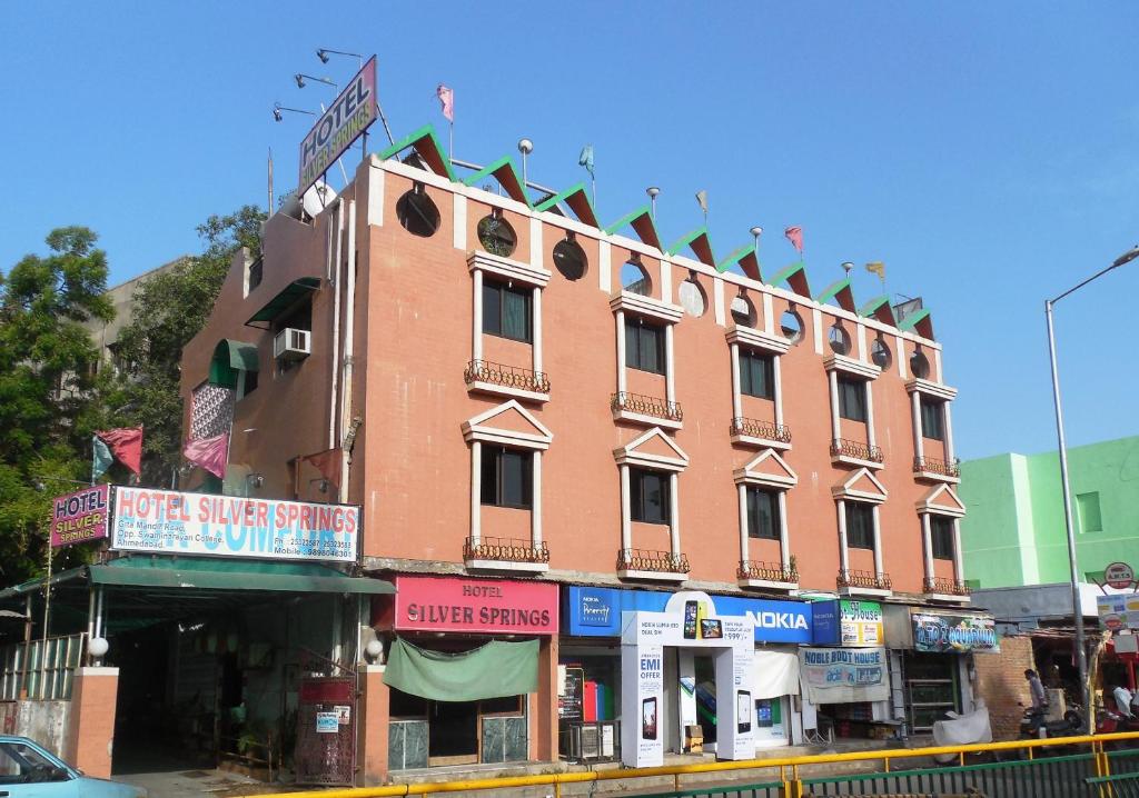 a large red brick building on the side of a street at Hotel Silver Springs in Ahmedabad