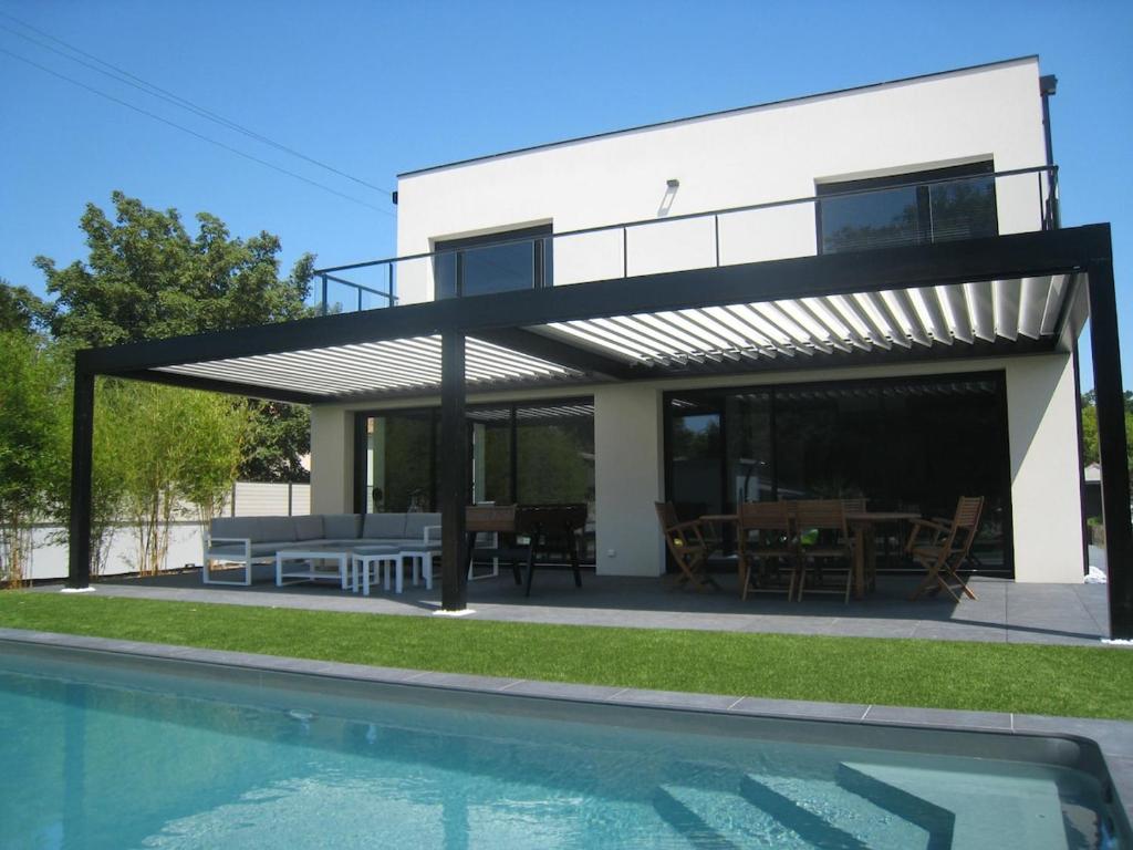 a house with a patio and a swimming pool at Villa proche de Bordeaux in Gradignan