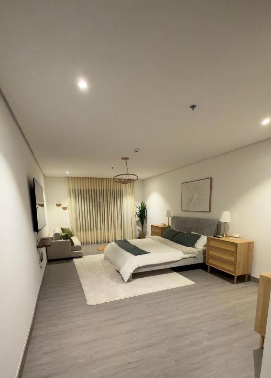 a large bedroom with a bed and a desk at 3BDS Luxury Stay Apartment - شقة 3 غرف للإقامة الفاخرة in Jeddah