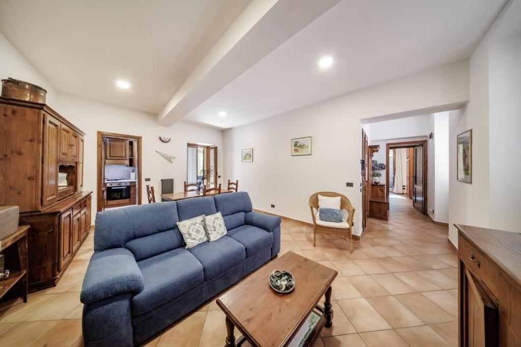 a living room with a blue couch and a table at Mella Bellagio Al Porto - Apartment with terraces near the Lake - Parking in Bellagio