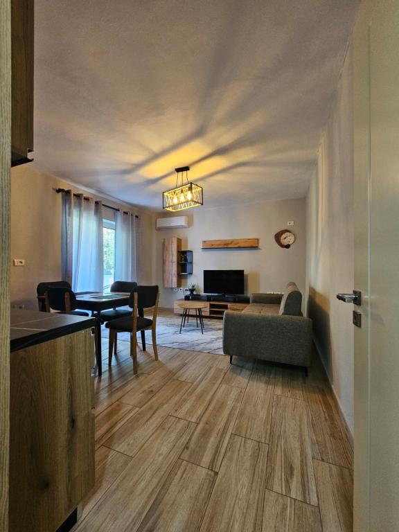 a kitchen and living room with a table and a couch at N'Shkoder in Shkodër