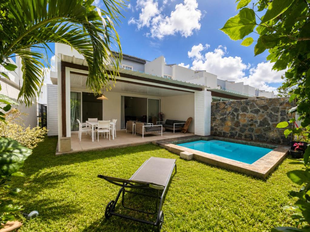 a backyard with a swimming pool and a house at Blue Zebra - Le West 24 in Tamarin