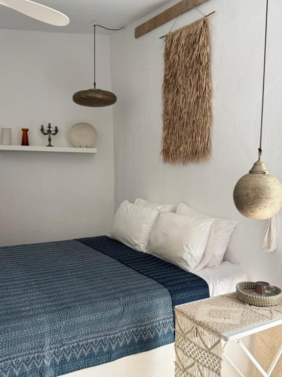 a bedroom with a bed and two pendant lights at St Pauls Batsi in Batsi