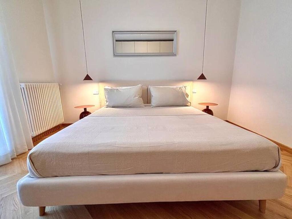 a large white bed in a room with two lamps at Modern Apartment Empoli in Empoli