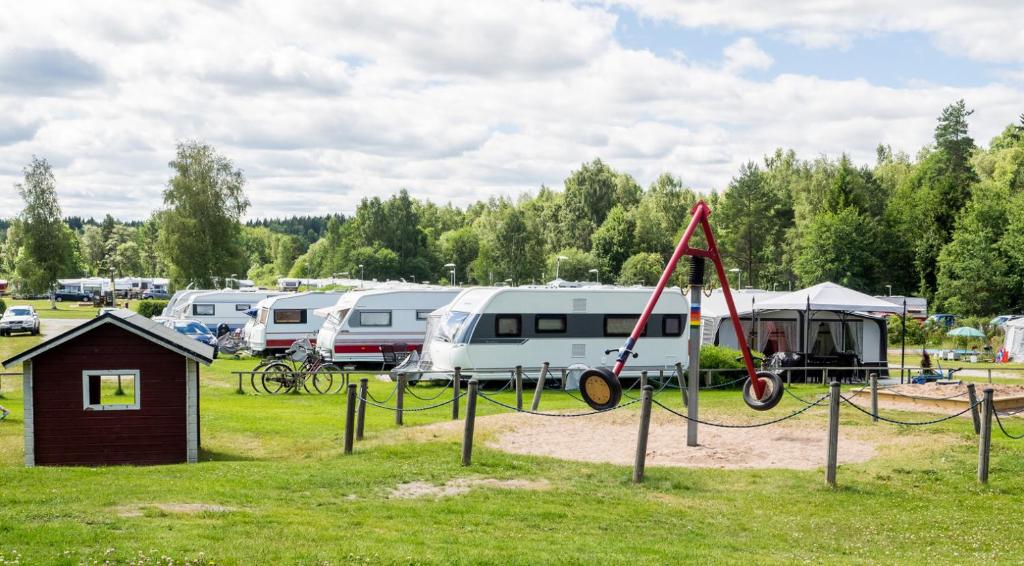 a campsite with a playground and parked rvs at Norbergs Camping in Norberg