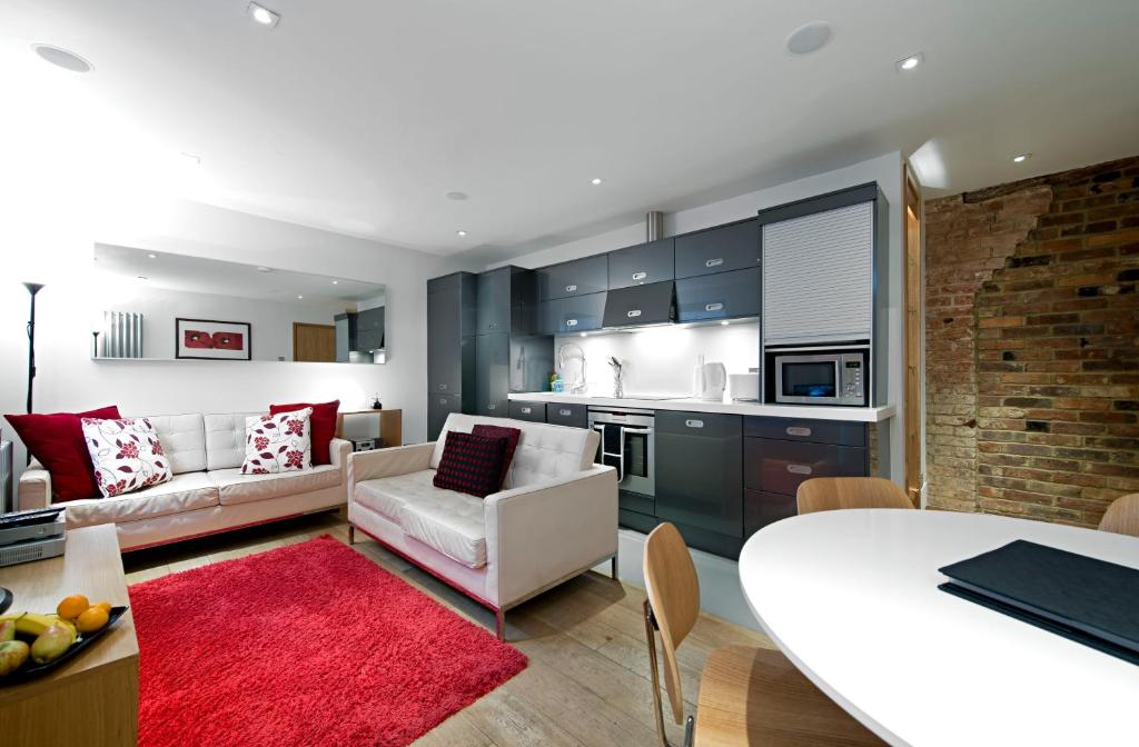 a kitchen and living room with a couch and a table at HomefromHolme St Peters Mews in St. Albans