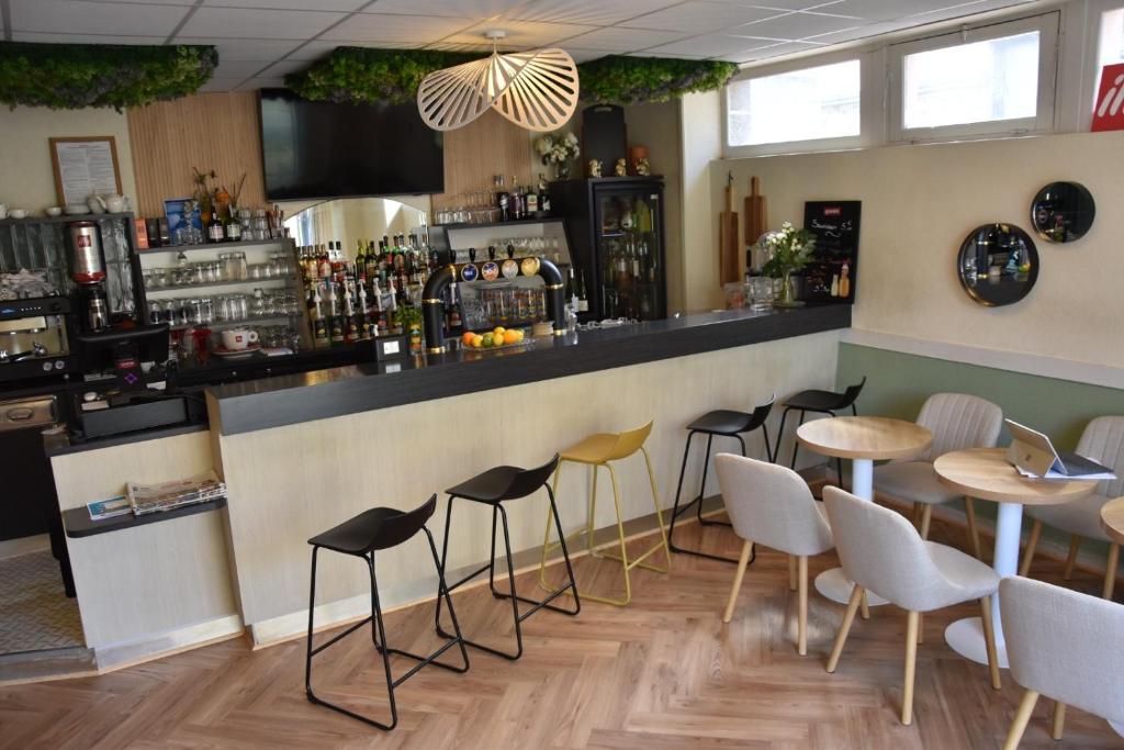 a bar with chairs and a counter in a restaurant at Au bon saint Nicolas in Hillion