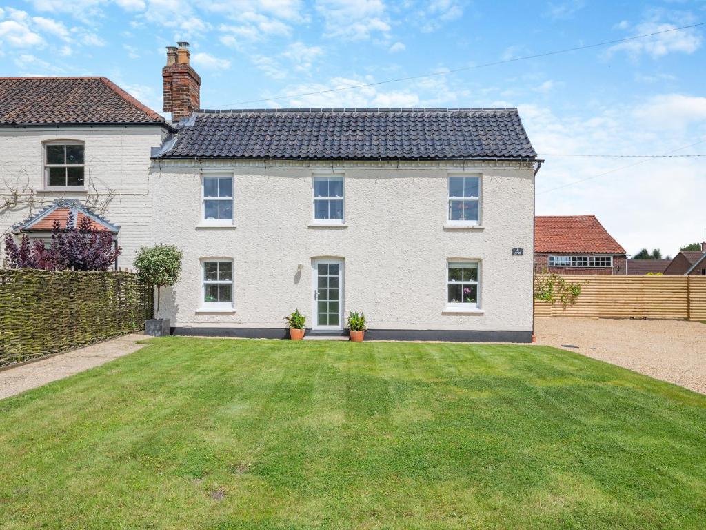 a large white house with a large yard at Manor Cottage in Longham