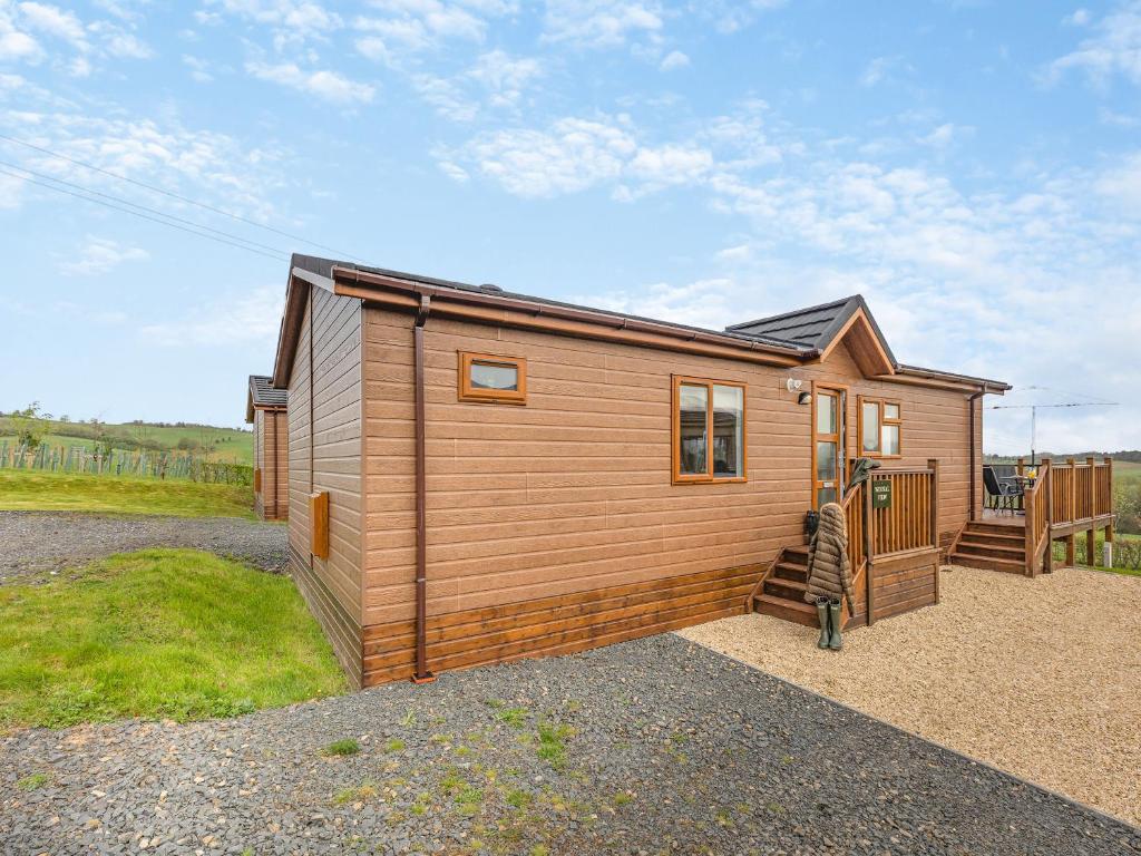 a small wooden cabin with a staircase in a yard at Winnal View - Uk46891 in Kinlet