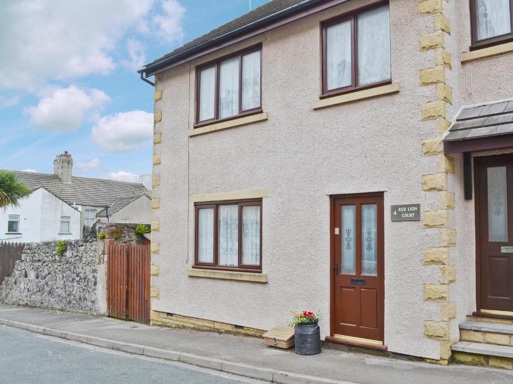 a white brick house with a brown door at Combe Cairn in Millom