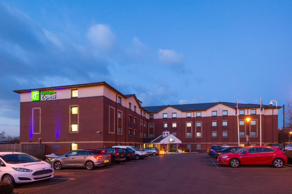 a large building with cars parked in a parking lot at Holiday Inn Express Bristol Filton by IHG in Bristol