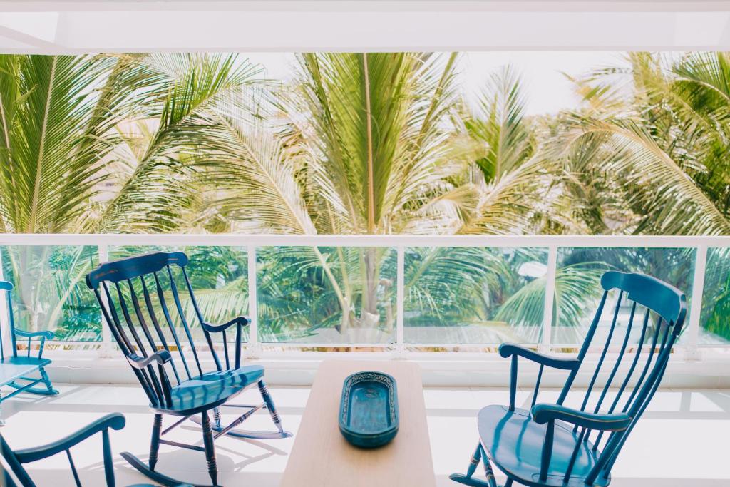 a room with three chairs and a table and palm trees at 3 Min Walk to Bibijagua Beach - Spacious 2BR in Punta Cana