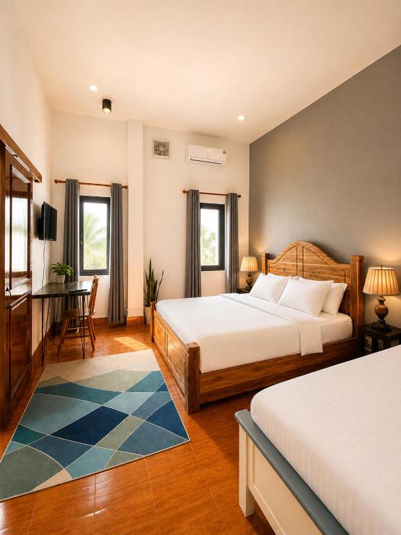 a bedroom with two beds and a table and chairs at Casa Primera in Luang Prabang