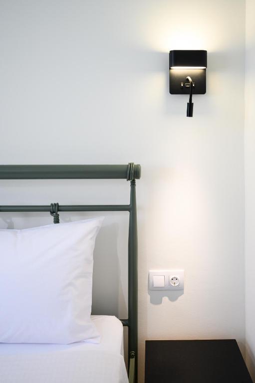 a hotel room with a bed and a light on the wall at Oropion Rental houses in Néa Palátia