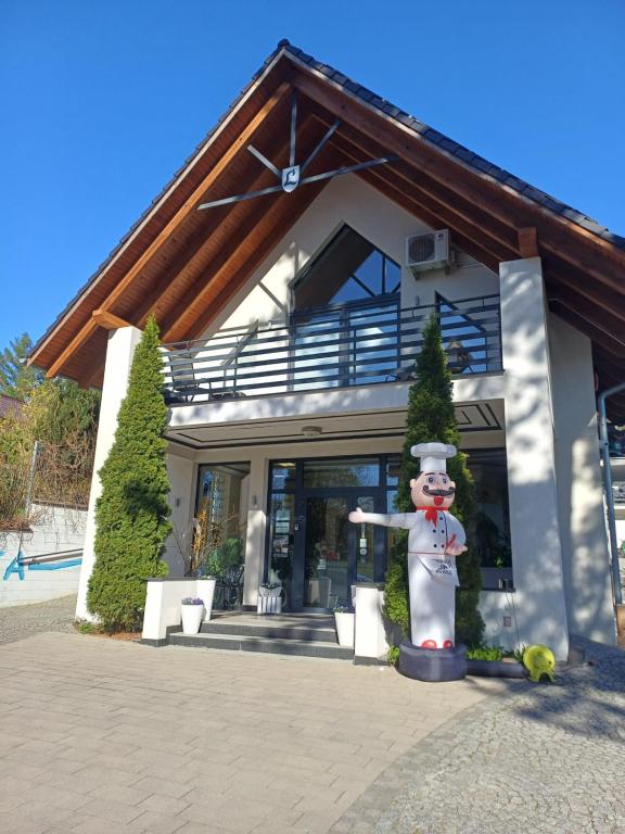 eine Statue vor einem Haus mit einem Gebäude in der Unterkunft Laura Spa in Łagów