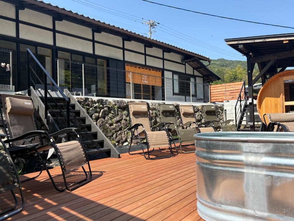 a building with chairs and a barrel on a deck at かきぞれ大黒宿ー1日1組限定 築120年の古民家と貸切サウナ完備 in Nakakiri