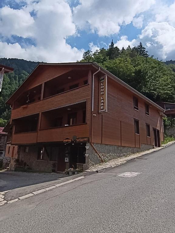 a wooden building on the side of a road at Long Lake pansiyon in Uzungöl
