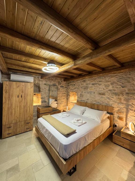 a bedroom with a large bed with wooden ceilings at Casa Di Lithos in Mestá