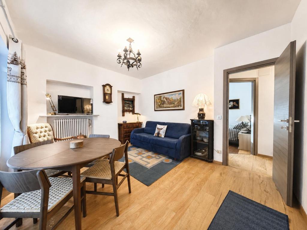 a living room with a table and a blue couch at Hostdomus - Fraiteve Suite in Sestriere