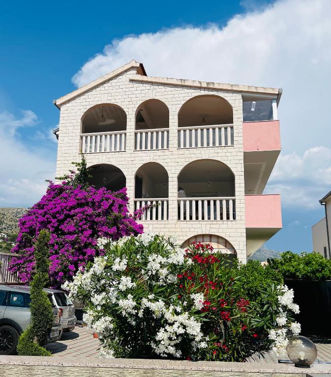 a building with flowers in front of it at Sea View Apartments in Grebaštica