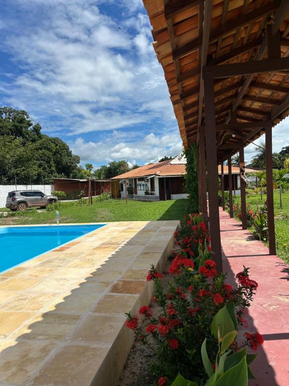 a backyard with a pool and a wooden pergola at Casa Mangue in Soure