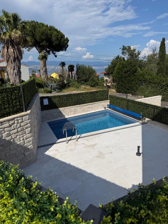 a swimming pool in front of a house at Aqua Azzuro Lovran in Lovran