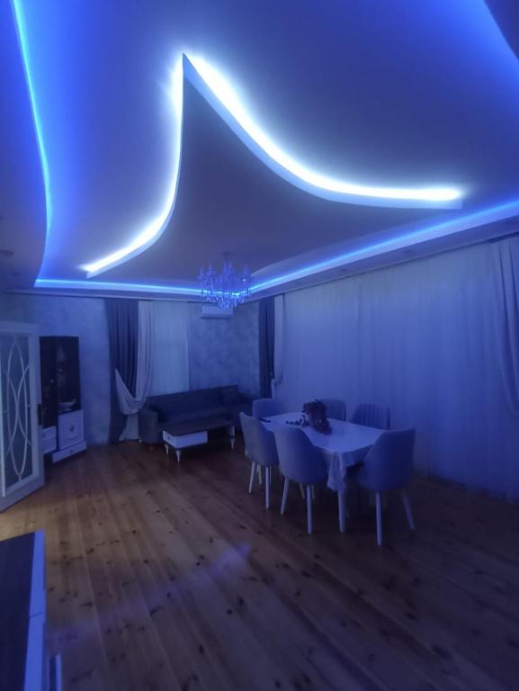 a room with a table and chairs and blue lights at Qebele gunluk ev in Bum