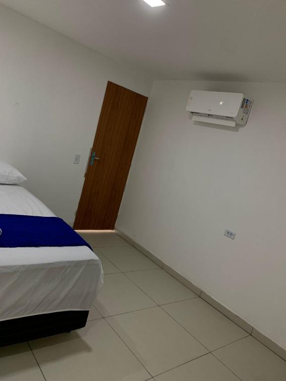 a bedroom with a bed and a heater on the wall at Pousada Monteiro Surubim in Surubim
