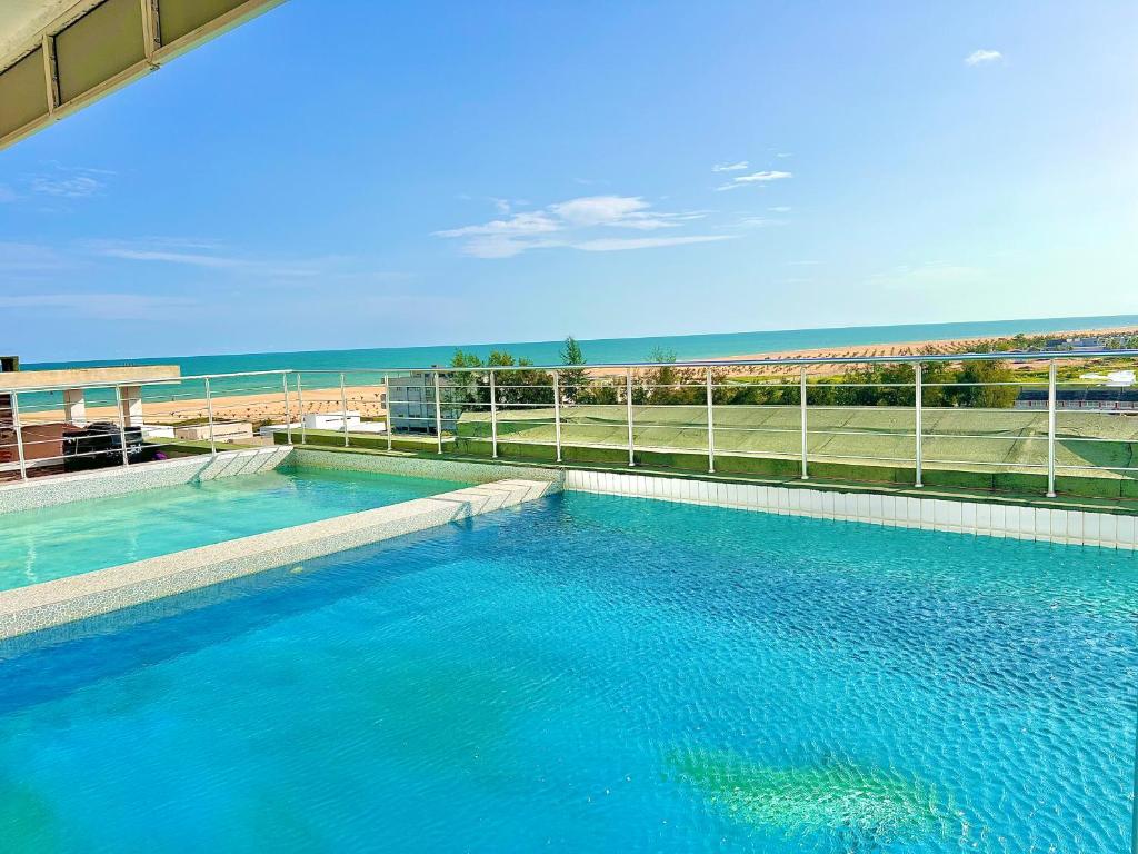 a large swimming pool with the beach in the background at Appart Hotel Les orchidees in Cotonou