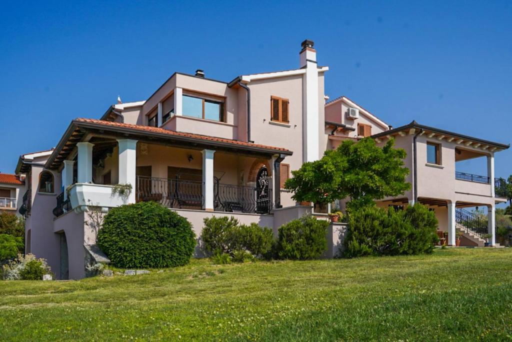 a large white house with a green lawn at Apartment Elio 1606 in Labin