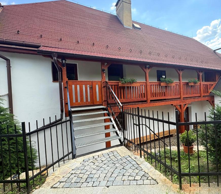 a house with a deck and stairs in front of it at Apartmán na statku in Teplice