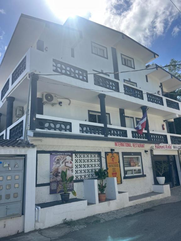a white building with a sign on the side of it at Hotel HILLMON in Sosúa