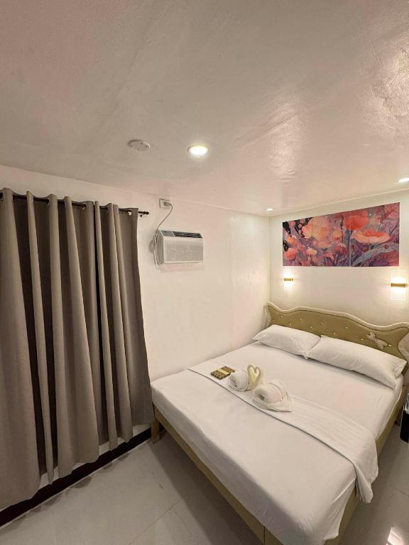 a bedroom with a bed with two towels on it at Camila Hostel Coron in Coron