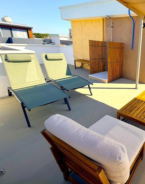 a deck with two chairs and a bed on a boat at Dune House in Ginosa Marina
