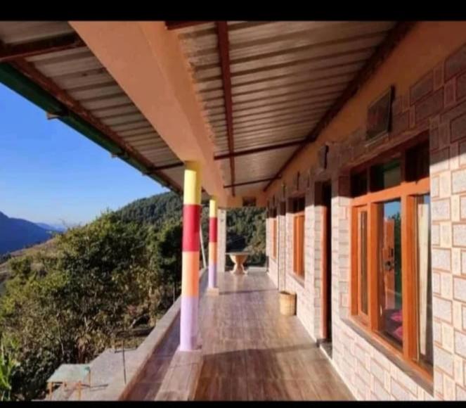 a porch of a building with a view of a mountain at Hariyali Homestay in Sari