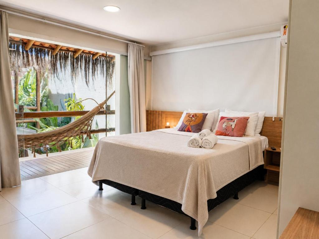 a bedroom with a bed and a large window at Pousada Divino Milagre in Passo de Camarajibe