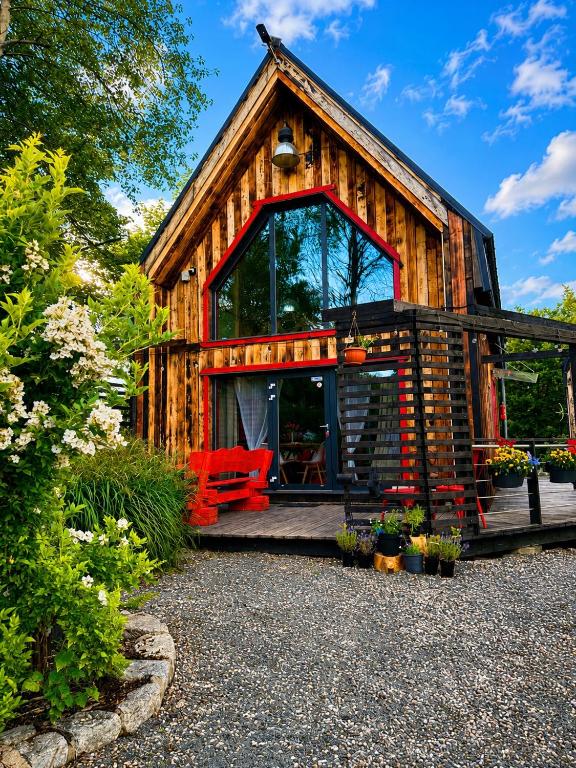 a log cabin with a red bench in front of it at Czerwona Stodoła Karkonoska in Podgórzyn