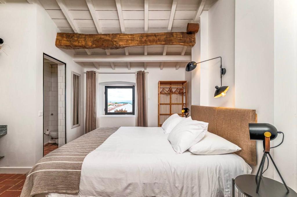 a bedroom with a large bed in a room at Quarto Duplo - Pacote Alentejo 3 Noites in Alcáçovas