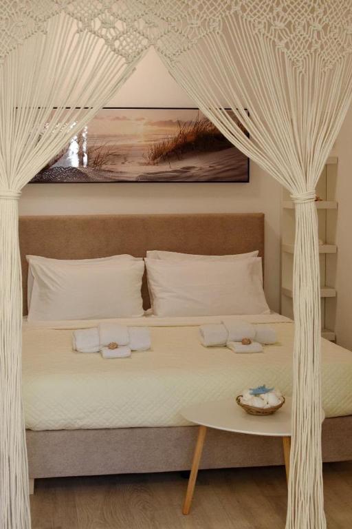 a bedroom with a bed with a canopy and a table at Rhodes Beach Side Houses in Ixia