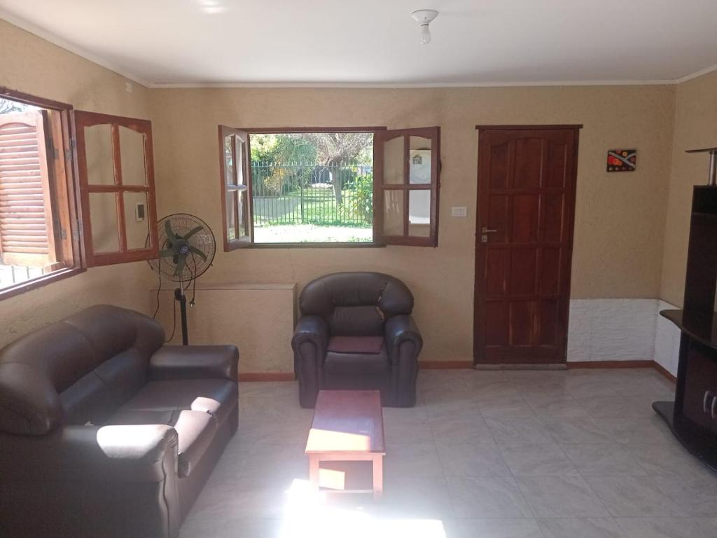 a living room with couches and a table and a tv at Lo de Rolo in Huerta Grande