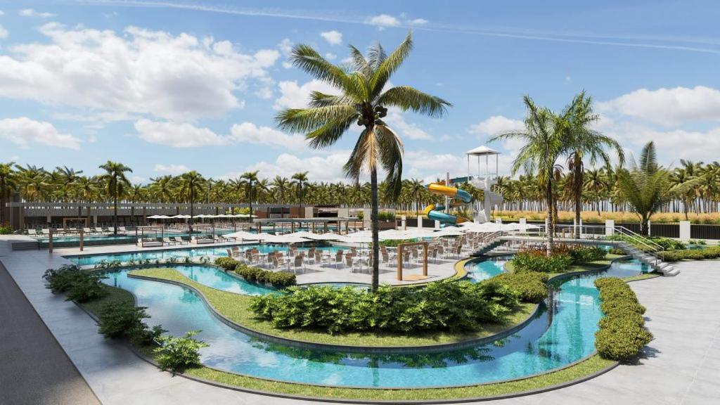 a resort pool with tables and chairs and palm trees at Gav resort beach in Salinópolis