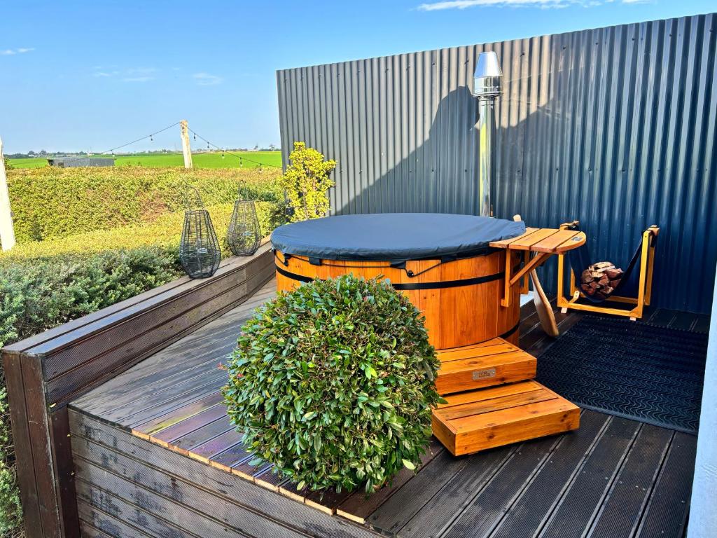 a hot tub sitting on top of a wooden deck at Libertas Guest Farm in Hoekwil