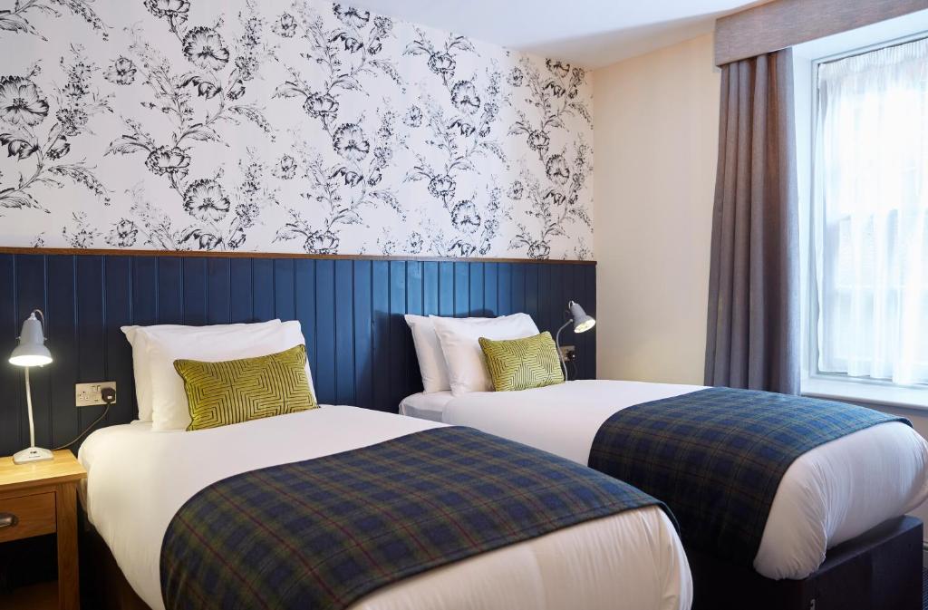 una camera d'albergo con due letti e una finestra di Swan Hotel by Greene King Inns ad Alton