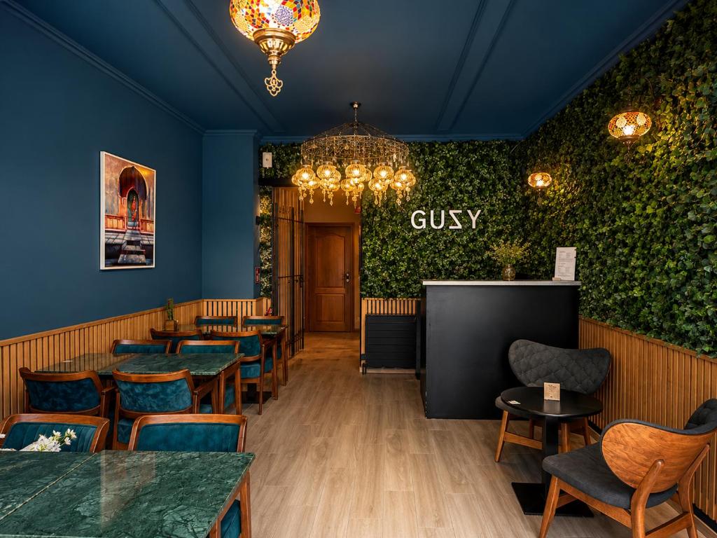 a restaurant with tables and chairs and a sign saying guilty at Hotel Guzy Lier Centre in Lier