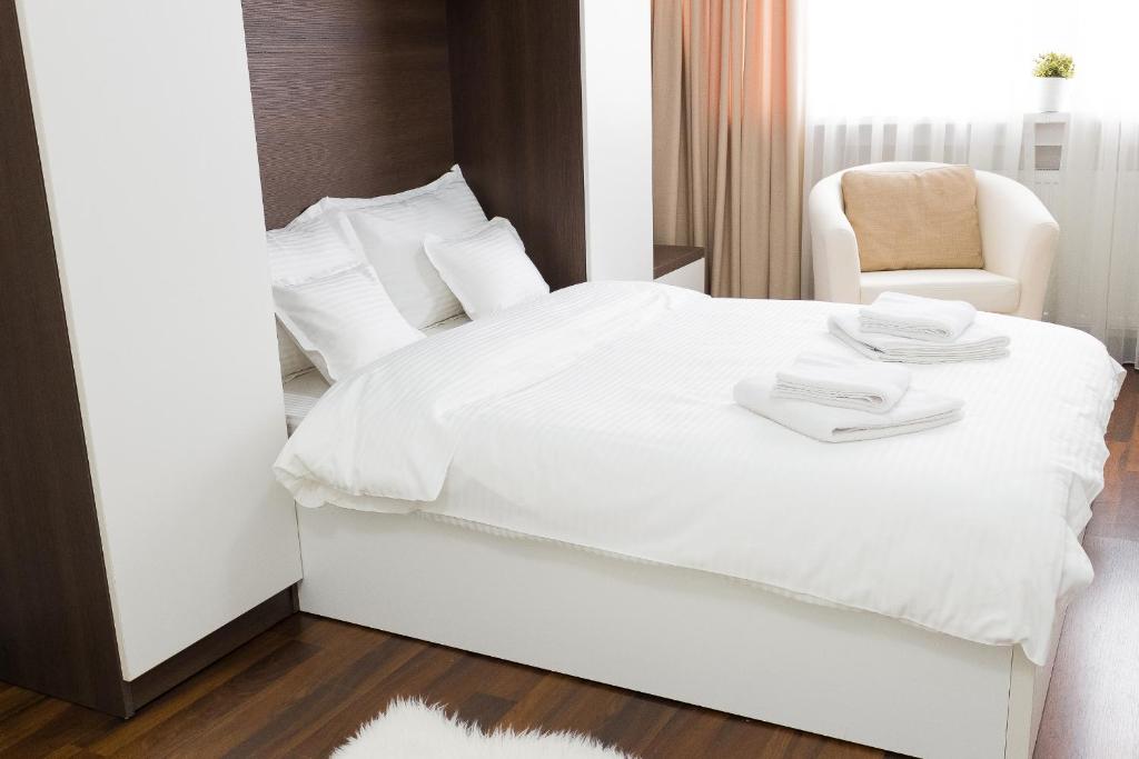 ブカレストにあるGrand Central Accommodation - Doamneiのベッドルーム(白いベッド1台、椅子付)