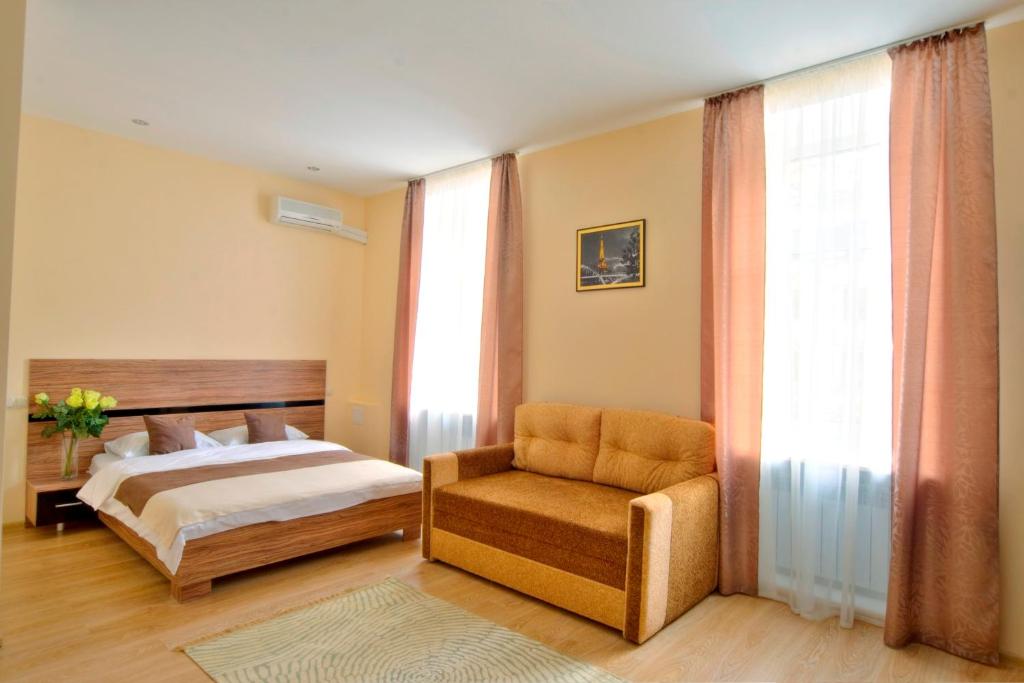 a bedroom with a bed, chair and a window at Sunday Apart Hotel in Kyiv