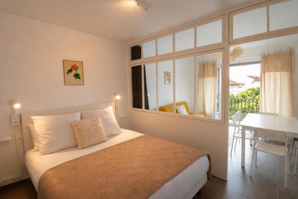 a bedroom with a bed and a table and a window at L'Albatros - Appartement de charme à Digoin in Digoin
