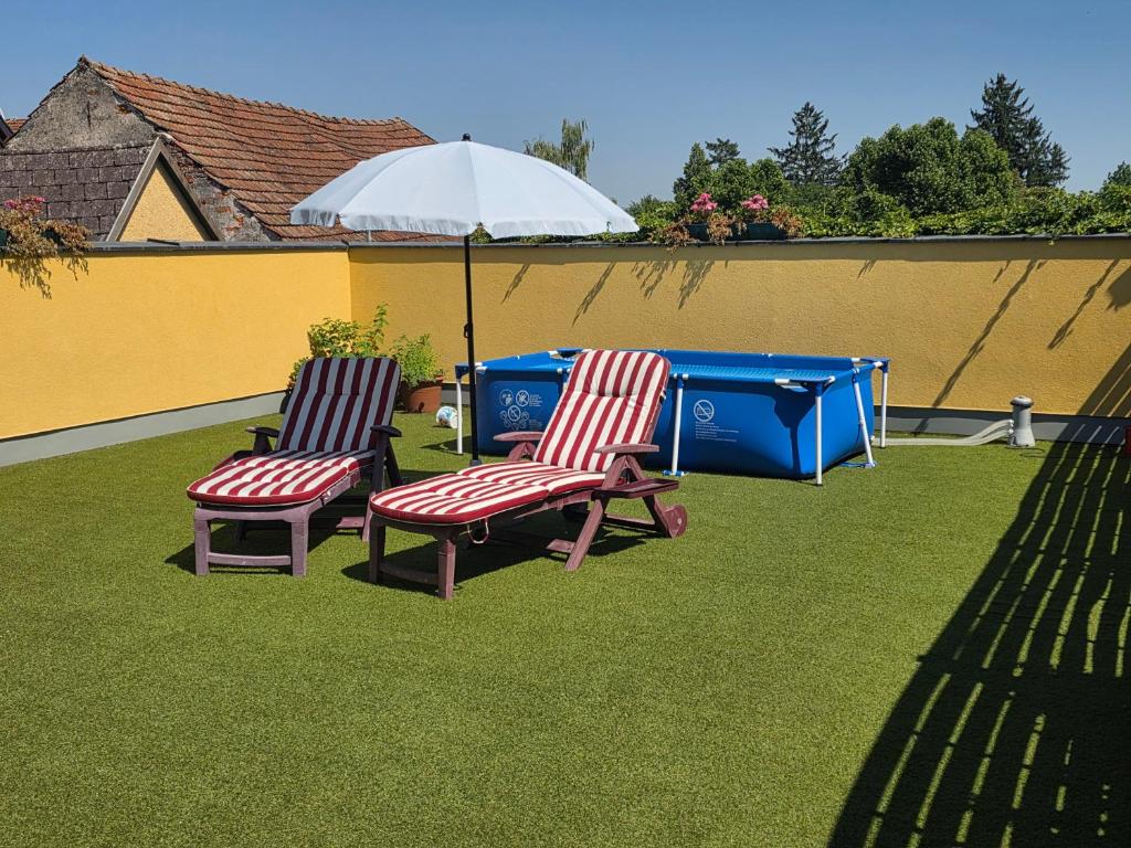 two chairs and an umbrella on a lawn at Hawa's Penthouse Studio with Terrace in Eferding