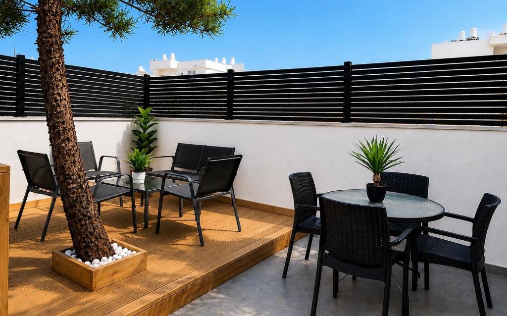 a patio with tables and chairs and a palm tree at סוויטת גן ליד הים in Qiryat Yam