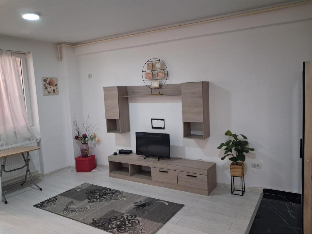 a living room with a flat screen tv on a wall at Modern 1-Bedroom Apartment with AC, Free Parking & Self Check-in Bucharest-Militari in Dudu